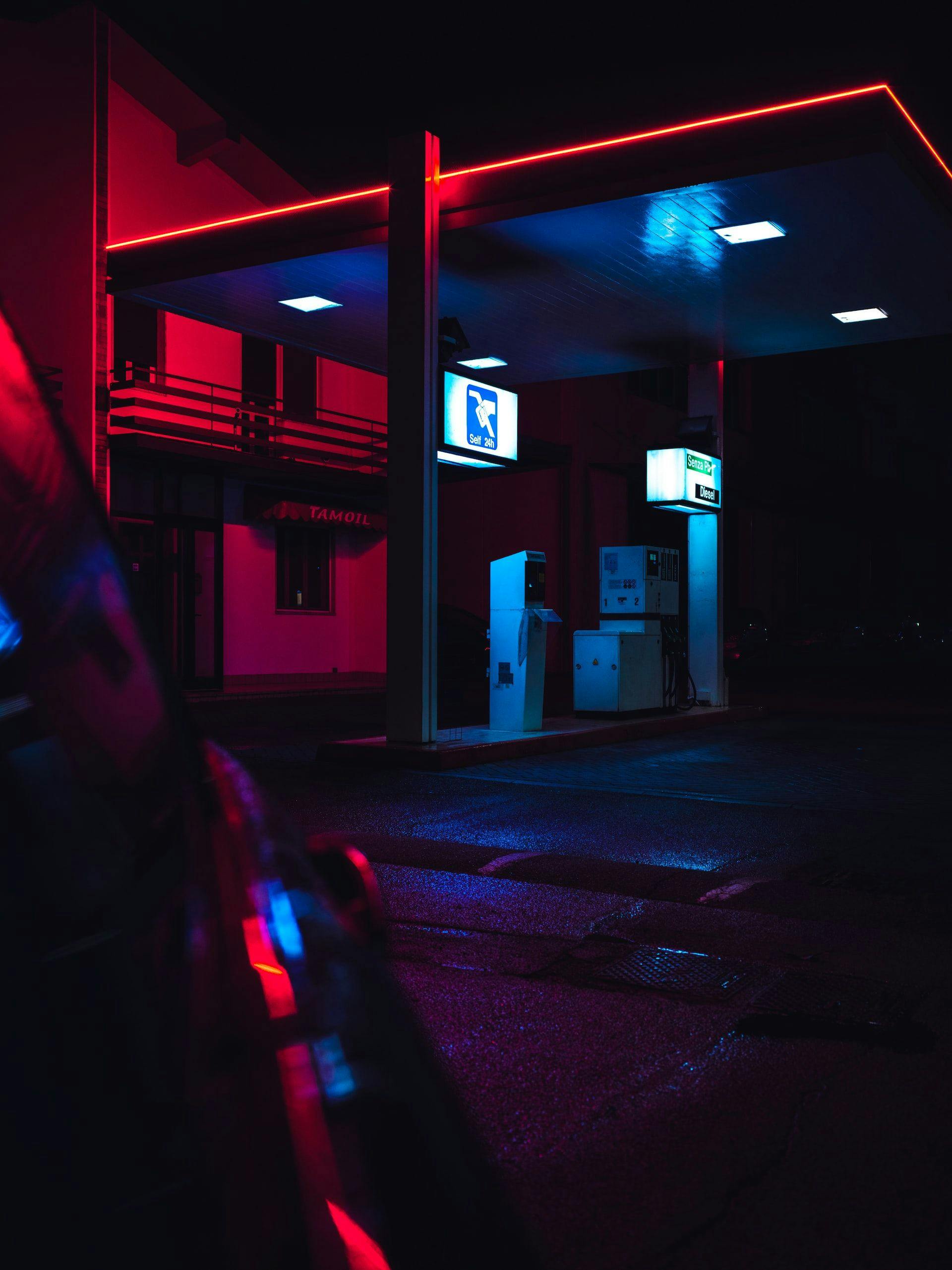 Gas station at night lit by neon sign